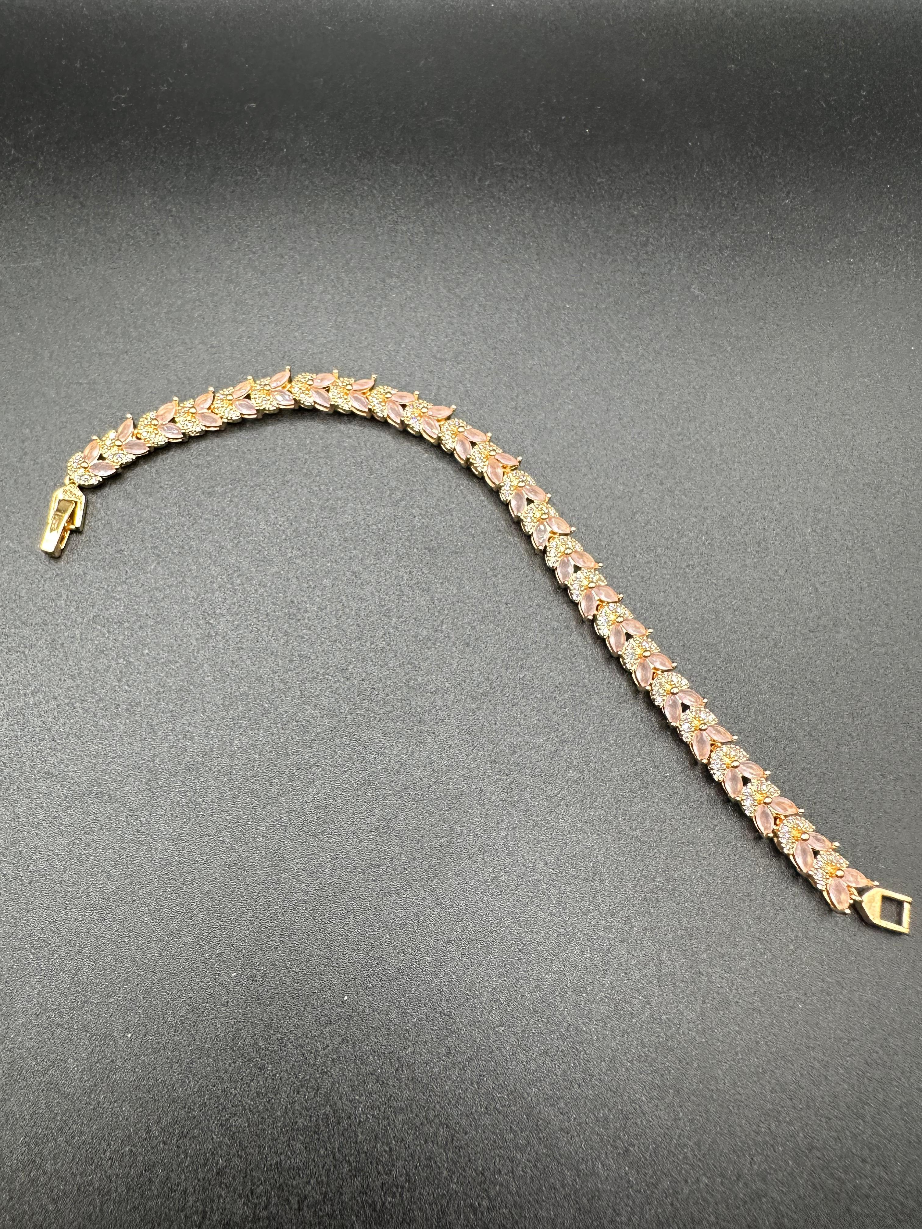 Zircon and light pink stones bracelet with golden base