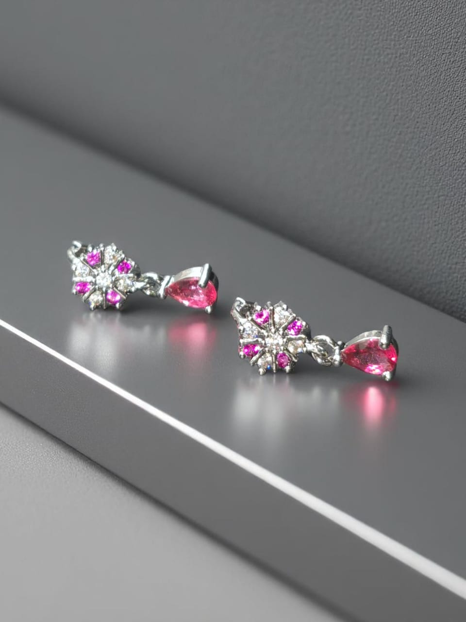 Dangle style silver earrings with pink stone