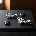 Dangle style silver earrings with black stone