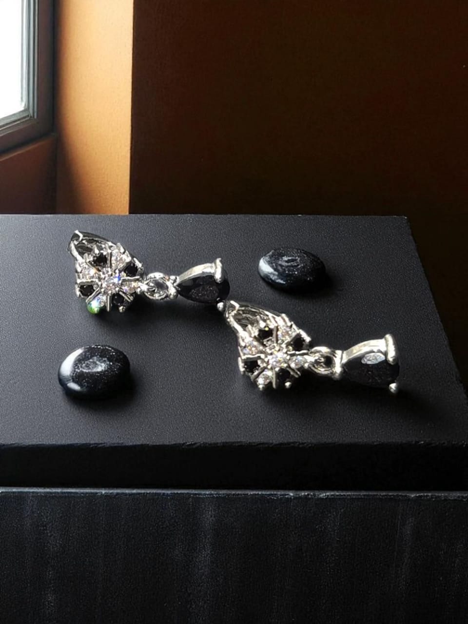 Dangle style silver earrings with black stone